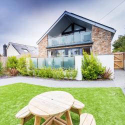 A view of the front of a holiday home with a grass area for picnics at the front